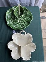 Green cabbage leaf chip and dip platter and iridescent white divided serving bowl with handle shown side by side