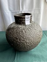 Front view of round textured Haeger pottery vase with narrow neck and rough pebble pattern texture.