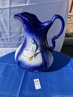 Full view of cobalt blue to white ironstone pitcher with duck decoration showing in natural light