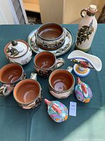 Image showing entire lot on table including serving dish, bowl, oil bottle, covered jar, 4 mugs, napkin holder, and fish salt and pepper shakers.