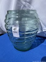 Front view of vintage green glass bee hive vase displaying ridged rings and overall shape.