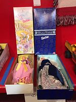 Photo showing both Spring Blossom Barbie and Winter Velvet Barbie in original Avon boxes, with dolls partially visible inside.
