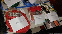 Three costume sets labeled 'belly dancer', '80's disco (woman)', and 'Cleopatra' on a table with other items.