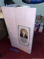 Photo of original pink box packaging showing size and branding of Rustie doll.