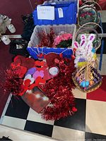 Valentine's Day and Easter decorations including heart-shaped cutouts, cupid and lips decorations, faux flowers, garland, and Easter baskets with decorative eggs and bunny figures.