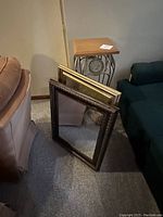 Photo showing two mirrors leaning against a wall and a plant stand behind them.