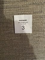 Photo of close-up texture of the beige fabric upholstery of the headboard with MaxSold sticker.