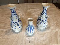 Three Bennington blue and white porcelain vases, two larger (10 inch) and one smaller (6 inch), on white cloth background.