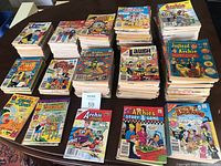 Multiple stacks of various vintage Archie Comics on a table, showing variety in titles and cover art.