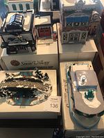 Overview of four ceramic Department 56 Snow Village pieces displayed on table