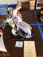 Full view of porcelain sculpture on wooden base with certificate