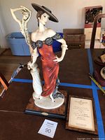 Full view of the figurine with certificate beside it on table
