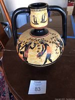 Front and side view of the urn showing the musical and bird painting on the body and curved handles.