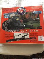 Front of the Lionel Pennsylvania Flyer train set box showing the complete set including track and locomotive with puffing smoke and powerful headlight details.