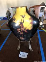 Full view of the ceramic pot on metal stand showing artwork.