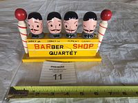 Front view of the barber shop quartet wooden bar kit with measuring tape showing approximately 7 inches wide.
