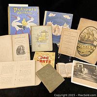 Overview photo showing all items including books with varied covers, a catalog with ship illustration, a framed print, and a postcard.