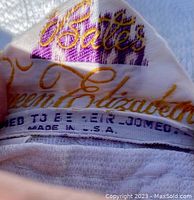 Close-up photo of the label inside the Bates "Queen Elizabeth" bedspread showing brand name, model, and origin USA.