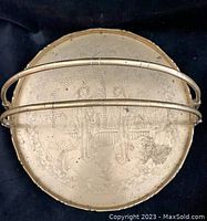Top front view of round brass-washed tray showing engraved scene and curved double handles with traditional Asian hinges.