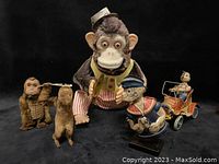 Photo showing all items: large battery-operated monkey holding cymbals, two small wind-up monkey toys, Popeye figure, and Happy Bunny driver toy car.