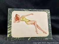 Cover image of the 1944 Varga calendar featuring a reclining woman in a green swimsuit on a marbled background.