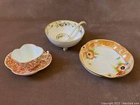 Three pieces of vintage Noritake and Nippon china shown together: pierced bowl, footed bowl with ladle, and transferware cup and saucer.