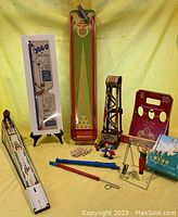 Full display of all toys in the lot including the bowling alley/shuffleboard game, ski-jumper game, chain lift, JOGO monkey, gymnast toy, musical instruments, and soda pop packages.