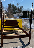 Full view of mahogany four-poster queen bed frame outdoors showing posts, headboard, footboard, and side rails