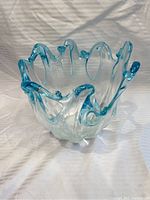 Front and angled view of turquoise blue Murano glass decorative bowl showing the wavy rim and clear-to-blue gradient glass.