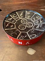 Top view of black steel drum surface with musical notes labeled in white.