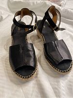 Top view of the pair of black leather Clarks artisan sandals showing open toe, ankle strap with buckle, and stitched sole.