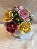Front angled view showing multi-colored porcelain roses in white vase