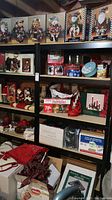 Shelves with assorted Christmas holiday decoration figures, tins, lights, tree skirts, and wreaths displayed in boxes and loose.