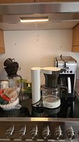 Photo showing the Braun coffee maker, coffee filters, and two glass coffee carafes on a stove top.