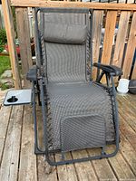 Full view of the zero gravity lawn chair showing the gray mesh seating, padded head cushion and attached side tray with cup holder.
