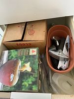 Photo of a cardboard box labeled 1-1/4 roofing nails, a fire bowl, and a packet of garden gloves