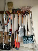 Overall grouping of long-handled tools against garage wall