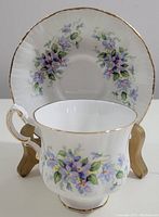 Tea cup and saucer set photos showing detailed views of floral pattern and gold trim.