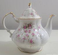 Front view of the tea pot showing overall shape, floral pattern, and gold trim.