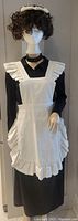 Front view of the mannequin wearing the uniform showing the black blouse, white ruffled apron, black choker, and white ruffled hat.