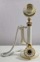 Full side view of the cream candlestick phone showing handset, push-button dial, and cord.
