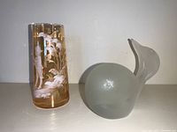 Photo showing both the cameo style amber glass vase with white etching and the frosted glass whale paperweight