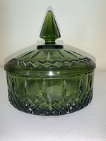 Front and angled view of Indiana Glass Avocado Green Goddess glass candy dish with lid and pointed finial knob.
