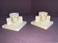 Pair of Roseville Pottery candlesticks shown side by side, square bases and delicate painted floral accents