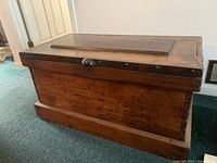 Front and side view of the entire chest showing stained wood finish and plinth base