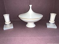 Front view of Lenox Olympia ivory gold trim lidded dish with two candlesticks on purple background