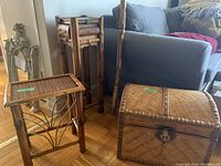 Three bamboo decor pieces - chest, small side table with drawer, and plant stand with woven tops and bamboo construction