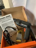Black and Decker drill with manual and drill bits inside original box.