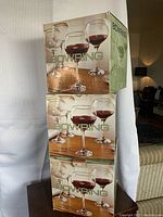 Three original Bowring boxes stacked, each box contains four balloon goblets, clearly brand new in unopened packaging.