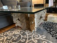 Front angle showing glass top and granite base with horse carving